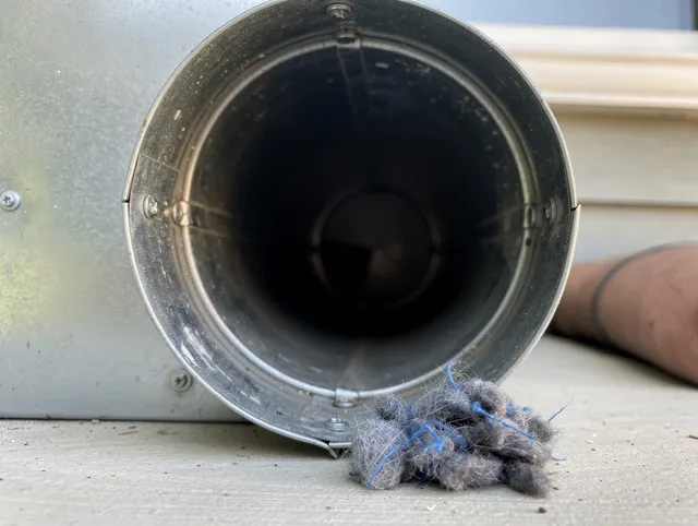 Boca Raton Dryer Vent Cleaning technician using specialized equipment to clear severe dryer vent blockage in Boca Raton